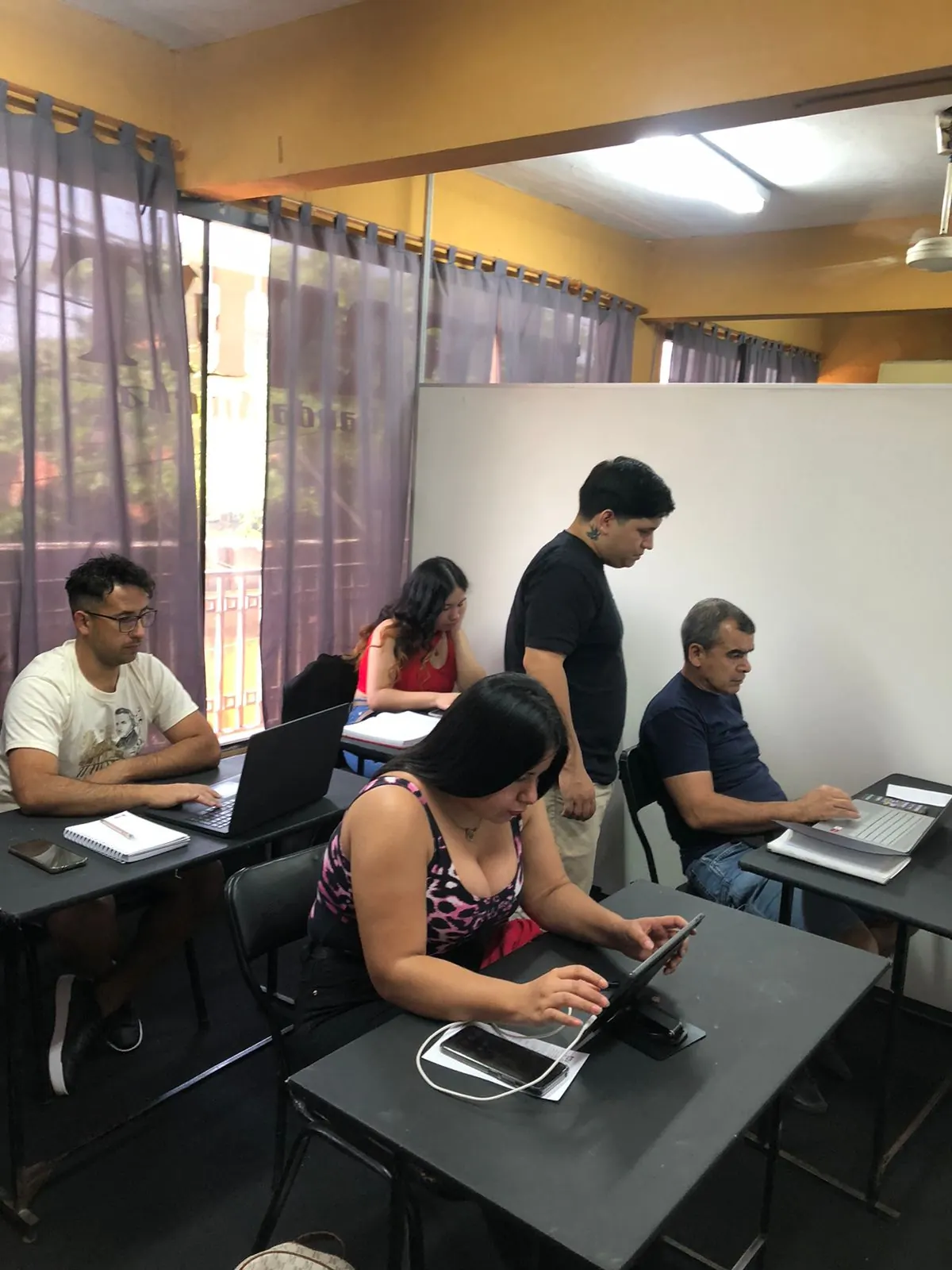 Clase de Informática con alumnos trabajando en notebooks
